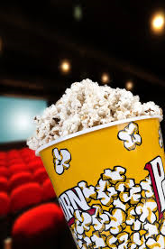 image of a bucket of popcorn with a blurry movie theater in the background