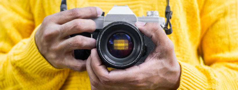 image of two hands holding a camera, facing the viewer