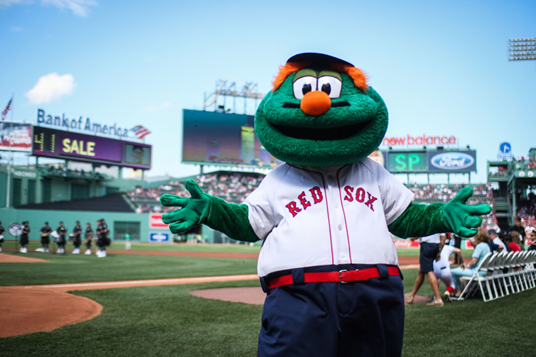 a green "monster" in a red sox jersey at Fenway Park